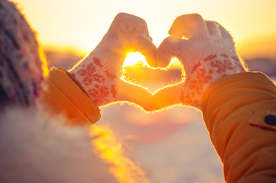 Sun shining through heart hands. Tips from therapists say to go outside and do things you enjoy. 